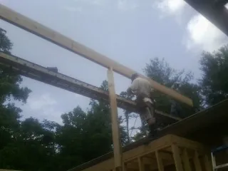 Carpenter setting a ridge beam over a new addition frame — Ice Dam Removal by Roofing Brothers in Clyman