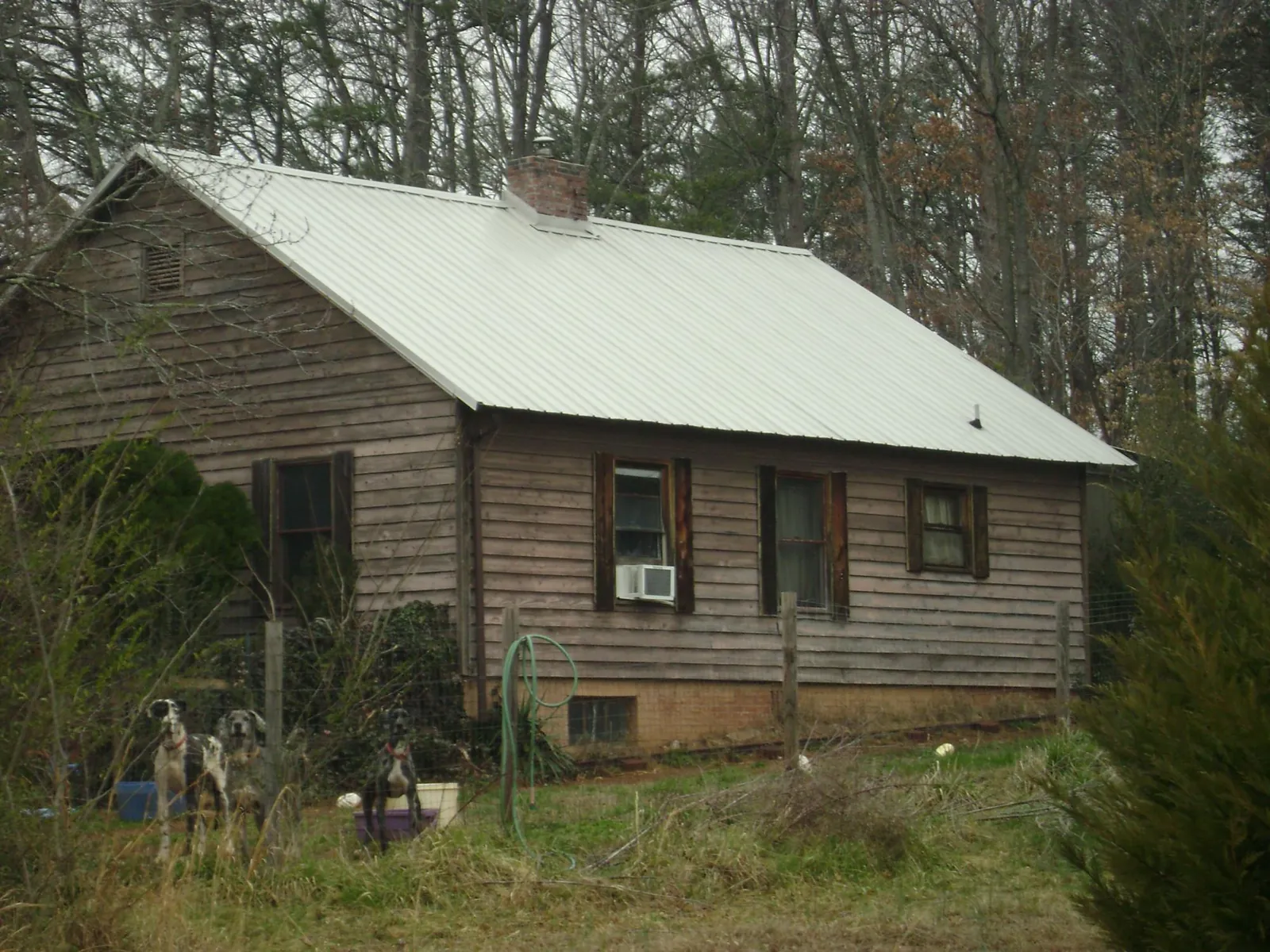 White metal roof on an old wood sided farmhouse, from a Metal Roof Installation job in Clyman